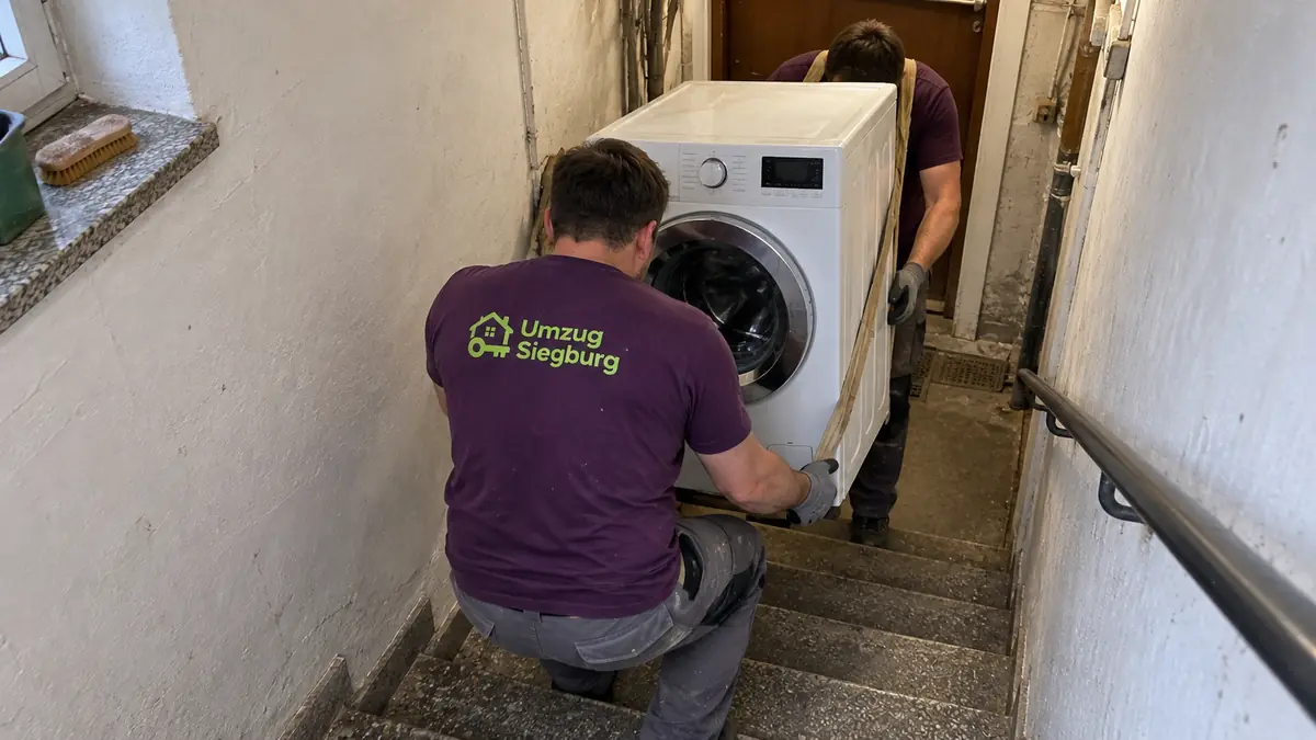 Umzugshelfer Siegburg tragen eine Waschmaschine die Kellertreppe hinauf